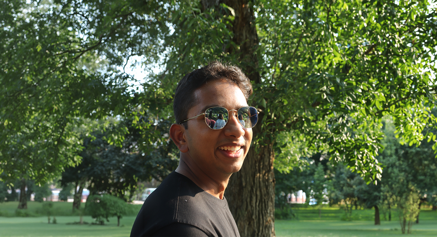Aditya Balaji smiling outdoors in a park